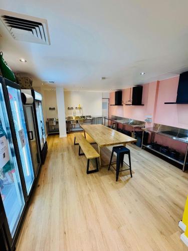 a large room with a wooden table and a kitchen at The Social Hotel, Sydney in Sydney