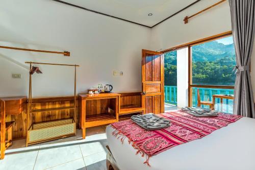 Un dormitorio con una cama y una ventana grande. en Sabaidee Nam Ou River View, en Nongkhiaw