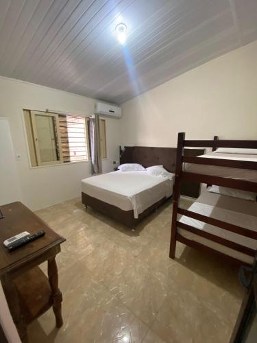 a bedroom with a bed and a nightstand and a bedsenalsenalsenalsenal at Pousada da Marli in Torres