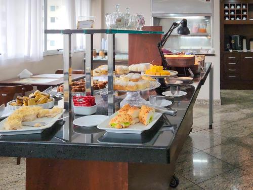 Un buffet con platos de comida en una mesa. en Triângulo Apart Hotel, en Vitória