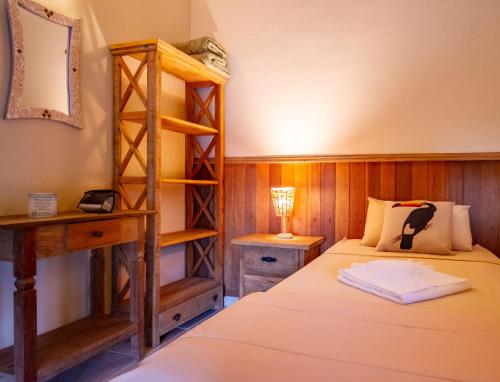 een slaapkamer met een bed en een boekenplank bij Pousada das Cavernas in Iporanga