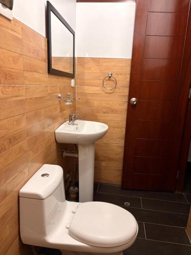 ein Badezimmer mit weißer Toilette und Waschbecken in der Unterkunft Kelly Mercedes in Chachapoyas