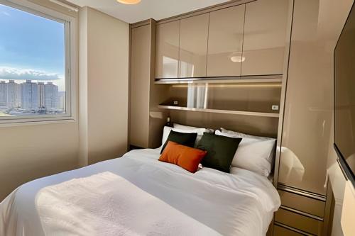 ヴィラ・ヴェーリャにあるPRAIA Mar e Sofisticação - Novo!の窓のある大きな白いベッドのある寝室