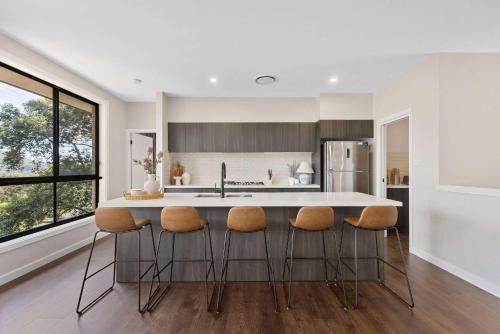 a kitchen with a large island with stools at Ruby Lodge by Coast Hosting in Green Point