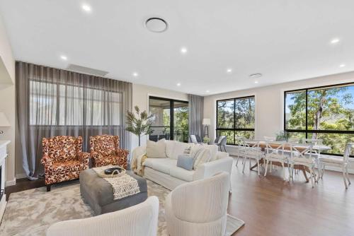 a living room with a couch and chairs and a table at Ruby Lodge by Coast Hosting in Green Point
