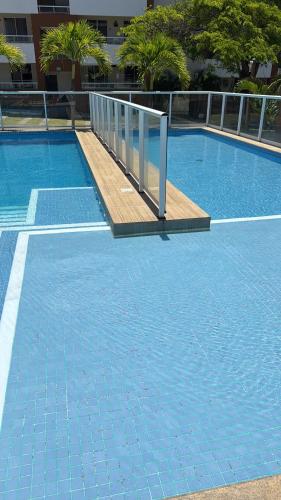 a blue tile swimming pool with a ramp in a building at Alugo apartamento em Guarajuba, e para réveillon! in Camaçari