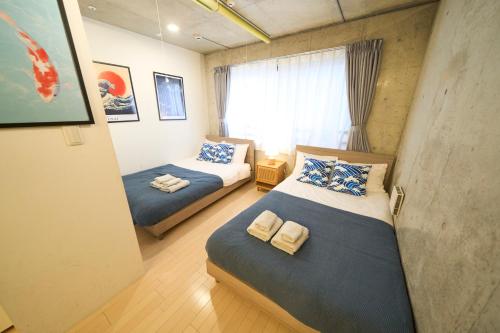 a bedroom with two beds and a window at ラフィット御徒町 in Tokyo