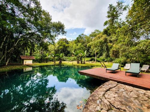 een zwembad met twee stoelen op een houten dek bij Pousada das Cavernas in Iporanga