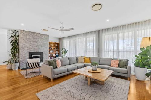 a living room with a couch and a table at Tarragal by Coast Hosting in Terrigal