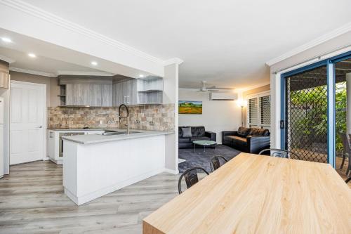 a kitchen and living room with a table and a kitchen and a dining room at Grange Resort Hervey Bay in Hervey Bay