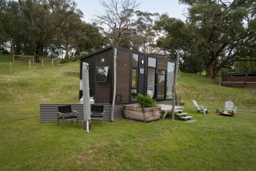 a tiny house sitting on top of a field at Acre Away by Tiny Away in Kangaroo Ground