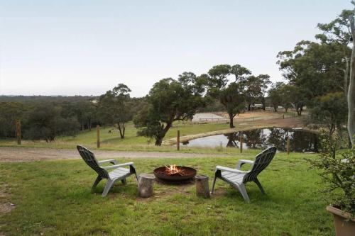dos sillas y una hoguera en el césped en Acre Away by Tiny Away, en Kangaroo Ground