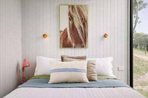 a bedroom with a bed and a picture of a horse at Acre Away by Tiny Away in Kangaroo Ground