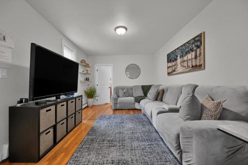a living room with a couch and a flat screen tv at Location+Comfort+Convenience in Boston
