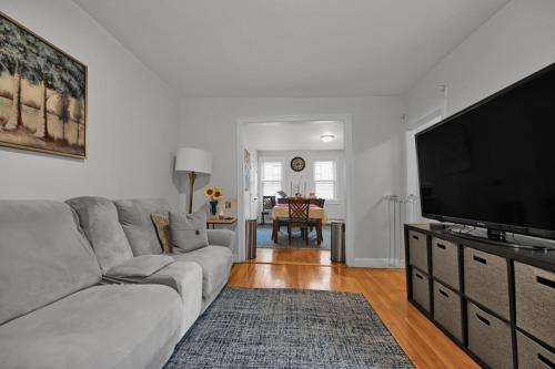 a living room with a couch and a flat screen tv at Location+Comfort+Convenience in Boston