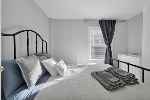 Un dormitorio blanco con una cama con toallas. en Location+Comfort+Convenience, en Boston