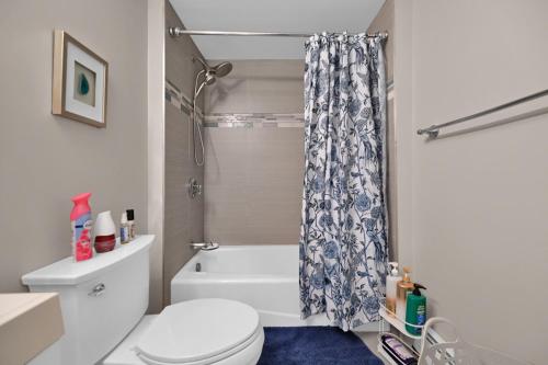 Un baño con inodoro y cortina de ducha. en Location+Comfort+Convenience, en Boston