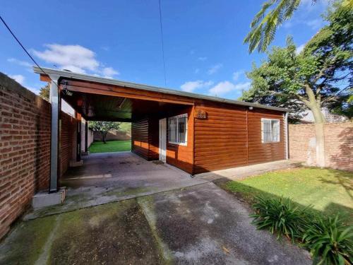 een huis met een garage met een stenen muur bij Cabaña zona vivero in Miramar