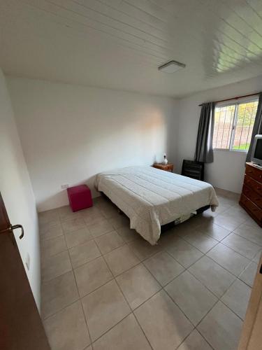 a bedroom with a bed and a tiled floor at Cabaña zona vivero in Miramar