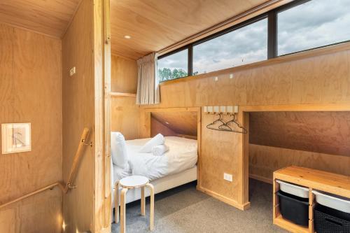 a small bedroom with a bunk bed and a desk at Mountain View Barn with Spa in Queenstown