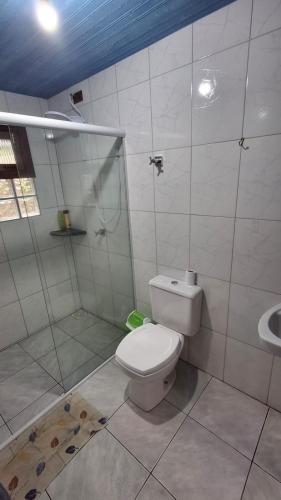 a white bathroom with a toilet and a shower at Alaercio goulart in Palhoça