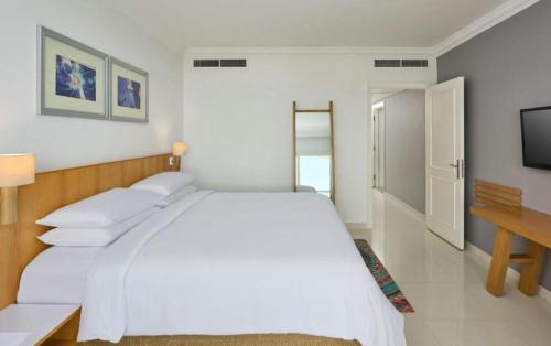 une chambre blanche avec un grand lit et un bureau dans l'établissement Rizkian pyramids view INN, au Caire