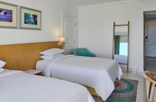 une chambre d'hôtel avec deux lits et un miroir dans l'établissement Rizkian pyramids view INN, au Caire