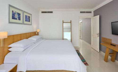 une chambre blanche avec un grand lit et une télévision dans l'établissement Rizkian pyramids view INN, au Caire