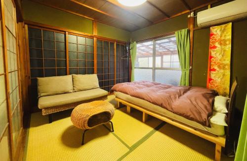 a bedroom with a bed and a couch and a window at Stay at matcha fields in Wazuka