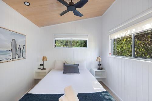 a bedroom with a bed and a ceiling fan at Reflections Scotts Head - Holiday Park in Scotts Head