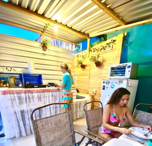 two women sitting at a table in a kitchen at Aloha Surf Hostel in San José del Cabo