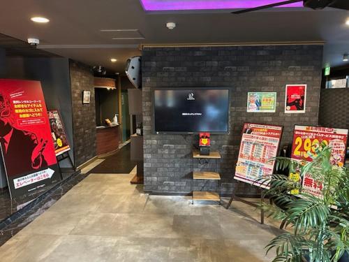 a room with a tv on a brick wall at ラグナ in Moriyama