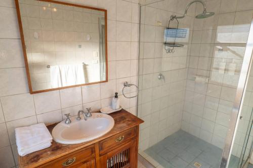 a bathroom with a sink and a shower with a mirror at Camillo Modern Family Retreat - with Private Pool