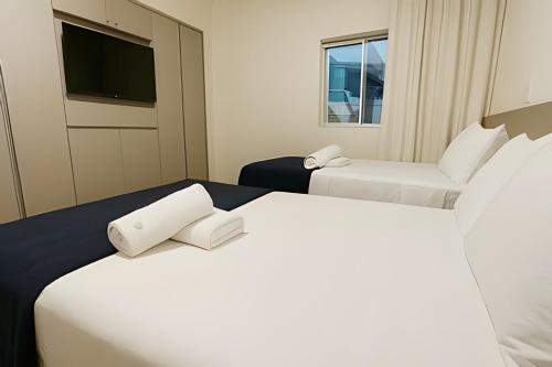 una camera d'albergo con due letti e una tv di Itaparica Beira-Mar [Confortável e Pé na areia] a Vila Velha