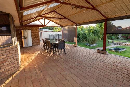 an enclosed patio with a table and chairs on it at Camillo Modern Family Retreat - with Private Pool