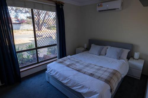 a bedroom with a bed and a large window at Camillo Modern Family Retreat - with Private Pool