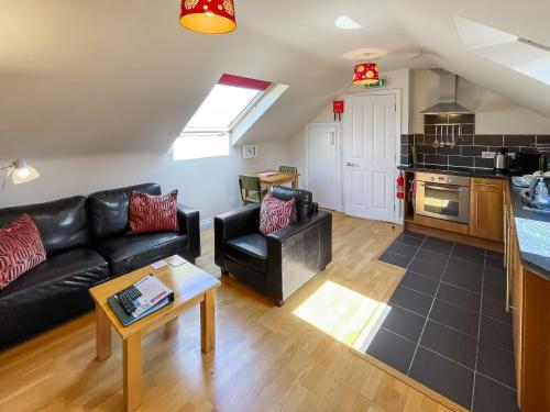 een woonkamer met een zwarte bank en een keuken bij Lauras Loft - Uk49740 in Fulletby