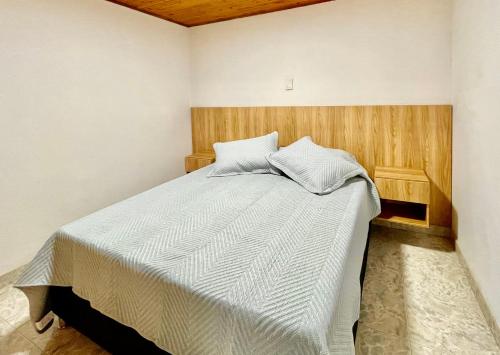 a bedroom with a large bed with a wooden headboard at Apto familiar 2 hab WiFi rápido y balcón in Sabaneta