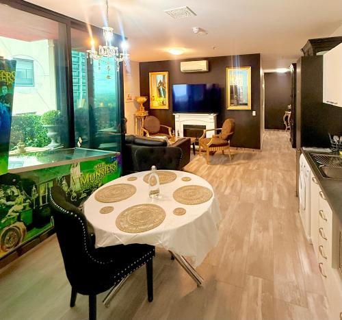 een keuken met een tafel en stoelen en een woonkamer bij UNIQUE CBD BOTIQUE STAY, BALCONY,NETFLIX,FREE WIFI,FREE Tram,FREE Bus,Walk to Rundle St, UniAdelaide, RAH, Casino, Pubs, Cafes in Adelaide