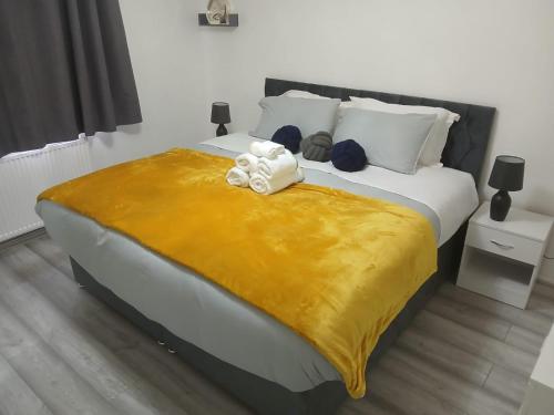 a bedroom with a large bed with a yellow blanket at Preferred Comfort Home Thornton Heath London in Thornton Heath
