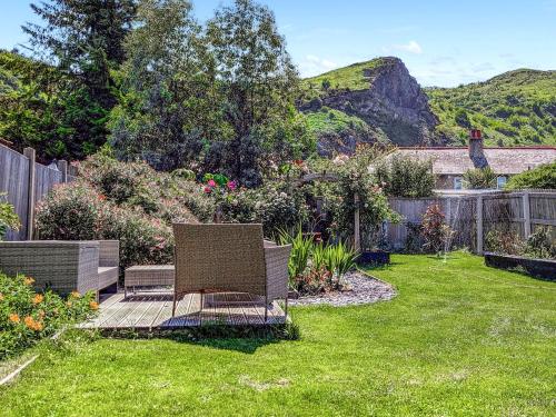 a garden with two chairs in the grass at Afallon in Conwy