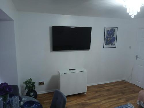 a living room with a flat screen tv on a white wall at Preferred Comfort Home Thornton Heath London in Thornton Heath