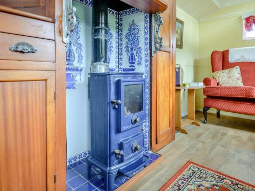 Una estufa azul en una habitación con una silla roja. en Mahalia, en Fordham