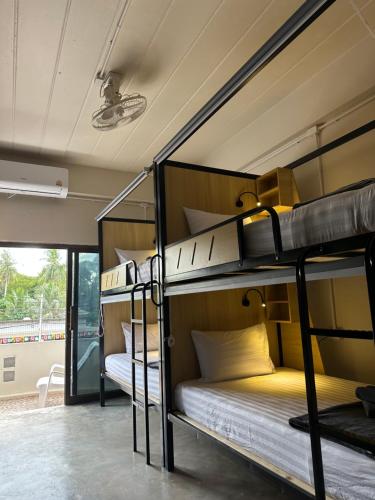 een kamer met 3 stapelbedden in een gebouw bij Sunnies 24 in Phra Ae beach