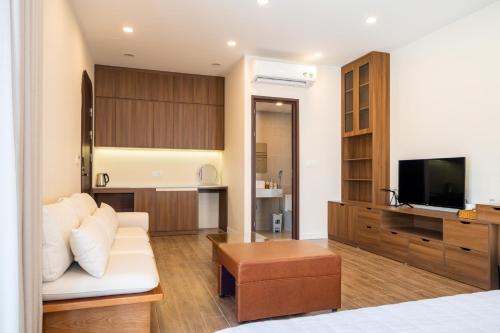 een woonkamer met een witte bank en een tv bij The Moon's House in Mộc Châu