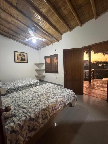 a bedroom with two beds and a ceiling fan at Casa Arena y Mar in Los Órganos
