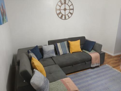 ein schwarzes Sofa mit bunten Kissen im Wohnzimmer in der Unterkunft Preferred Comfort Home Thornton Heath London in Moffat