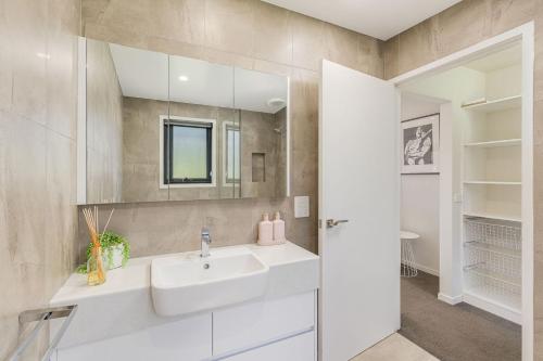 un baño con lavabo y espejo en Sirocco on Main, en Merimbula