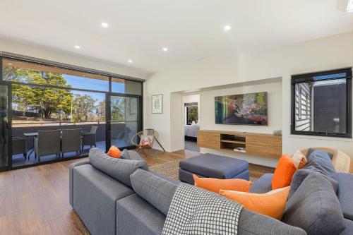 a living room with a couch and a tv at Sirocco on Main in Merimbula