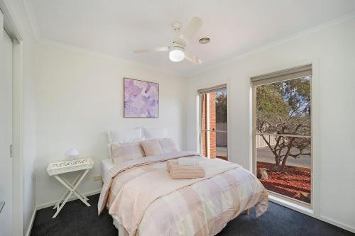 ハミルトンにあるBlue Bird Villa Hamiltonのベッドと窓のある白い寝室